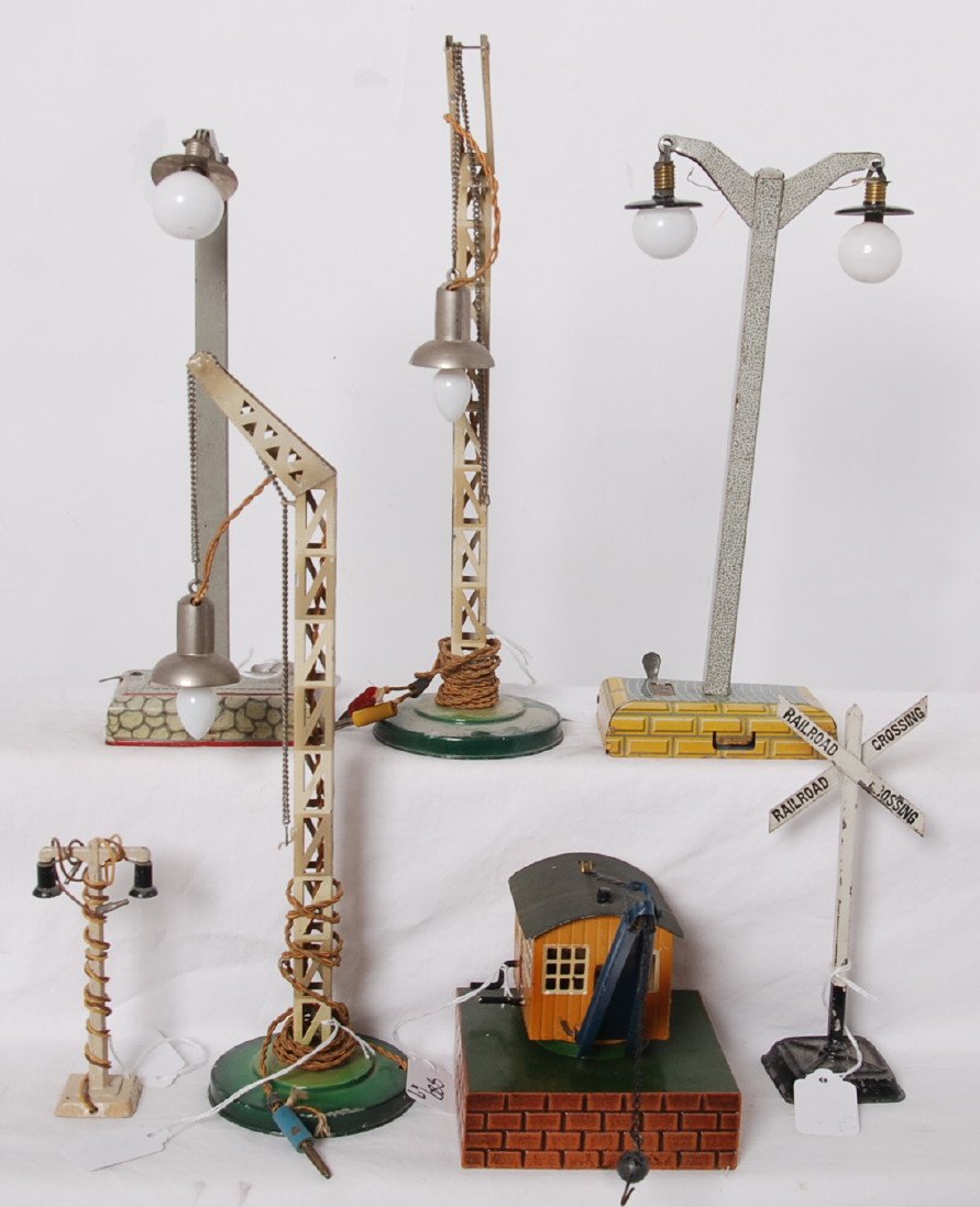 Marklin derrick/crane, RR crossing, five street lamps: Postwar Marklin HO, O, and standard gauge accessory items. Operating/spinning crane, Railroad crossing sign, five street lamps, C6-8.