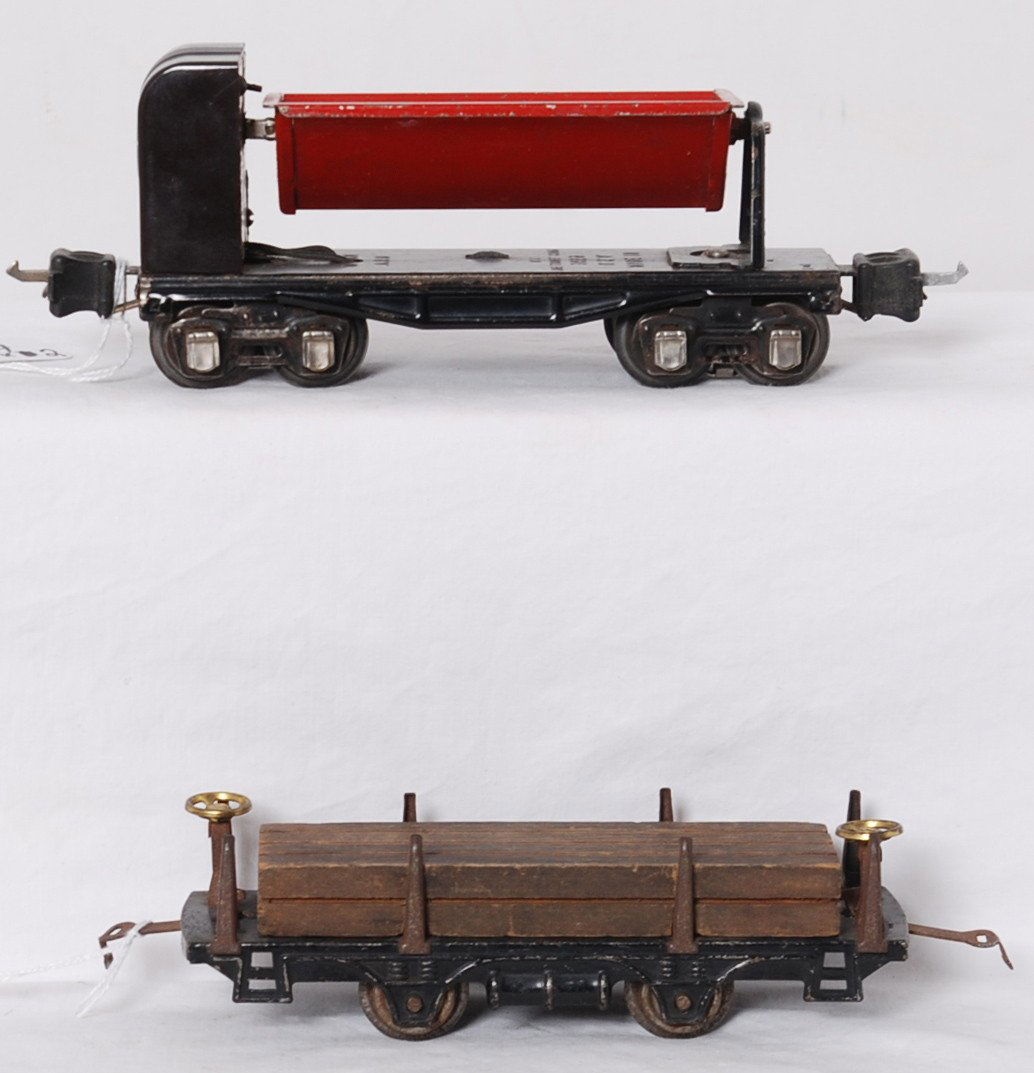 Two unique Lionel prewar freight cars, 3659, 831: Prewar Lionel O gauge 831 flatcar with lumber load, more unusual car has eight stakes, surface rust C6. 3659 automatic dumping car with more unique brown mechanism cover, better C6.