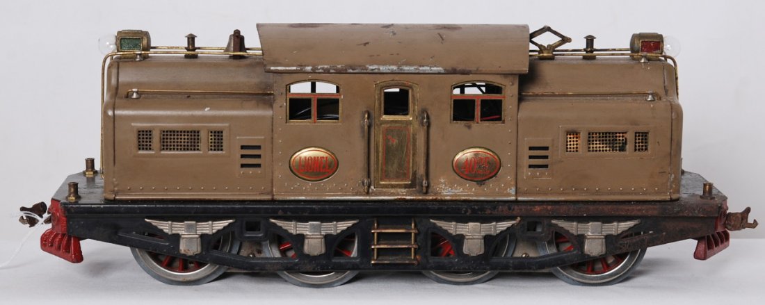 Lionel 402E standard gauge dual motor electric loco: Prewar Lionel standard gauge 402E center cab electric locomotive in mojave with brass plates and ventilators. Shell has grime and loss of paint. Frame has surface rust. Motors have been rewheeled and 