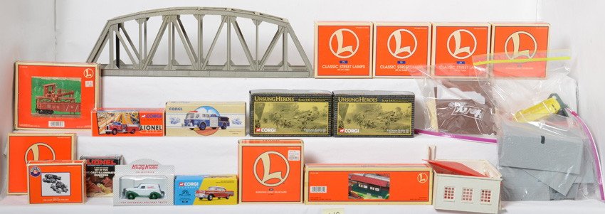 Lionel track side accessories, Corgi diecast, and Plast: Modern O gauge track side accessories. Lionel items include two 12974 blinking billboards, 12706 barrel loader building, three 12874 street lamp sets, 62180 railroad signs, 14078 diecast trucks, 12731