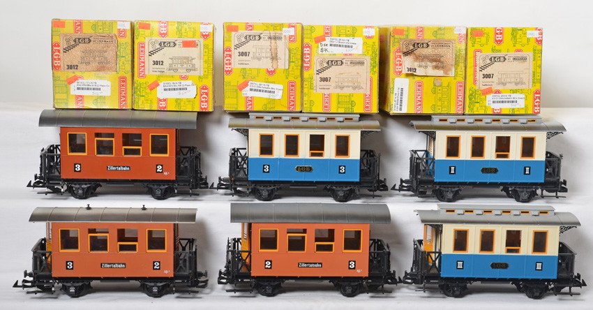 6 LGB passenger cars 3007 3012: LGB modern G scale passenger cars in OBs. Six cars include three 3007 brown 3/2 coaches, two blue and white 3012 III/II coaches, and 3012 3/2 blue coach. OBs have shelf wear, staining, and price stick