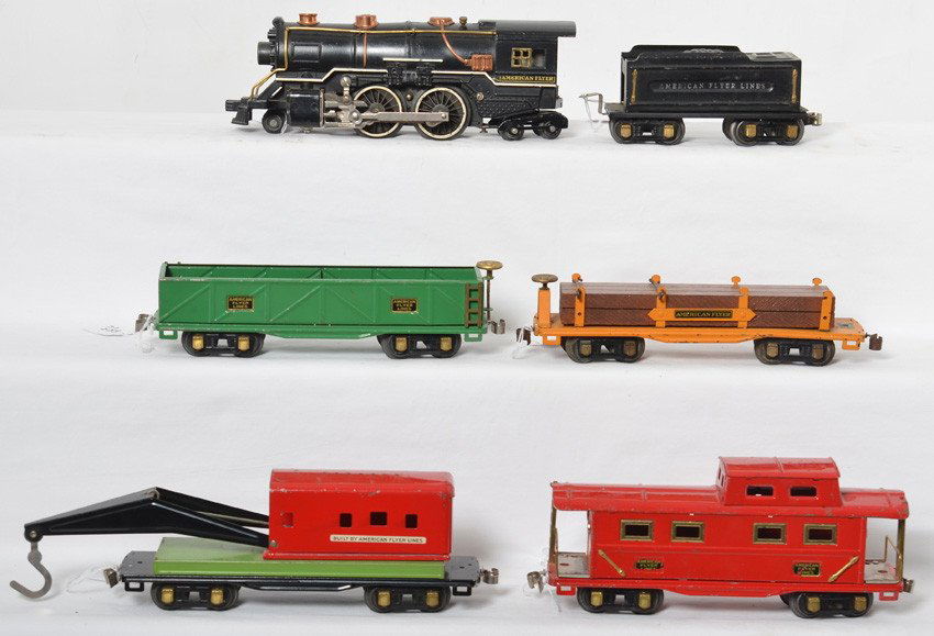 American Flyer O ga. loco & tender and four freight: Prewar American Flyer O gauge steam locomotive and tender with four freight cars, sand car, lumber car, derrick, and caboose, C6-7. Loco has casting fatigue to some lead and trailing truck wheels.