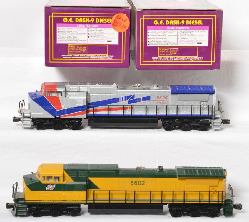 MTH C&NW and GE Demo Dash-9 locos with Proto: MTH modern O gauge Dash 9 diesel locomotives in OBs. Both locos feature Protosound, Protosmoke, Protocouplers, and more. Includes 20-2159-1 Chicago and Northwestern and 20-2160-1 GE Demonstrator. Loco