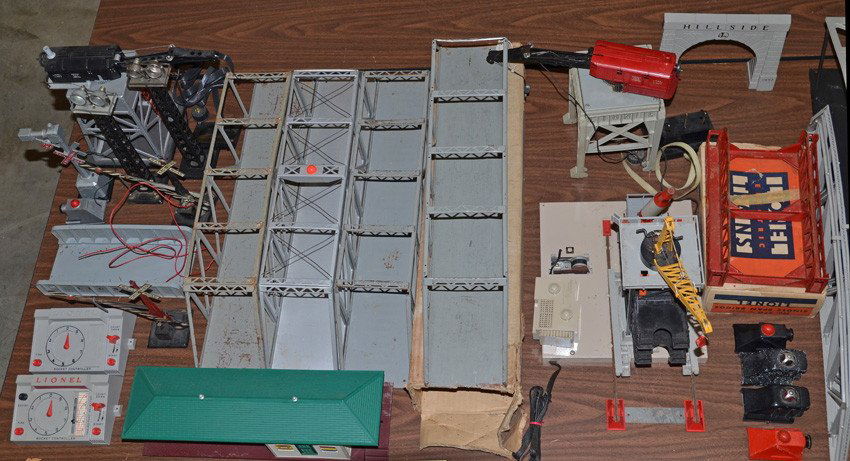 Large lot of Miscellaneous postwar Lionel: Postwar Lionel, Marx, and Plasticville O gauge accessories, including 282 and 182 cranes, 175 rocket launcher, 450 signal bridge, 445 switch tower, five bridges, 256 station, plus many other items as
