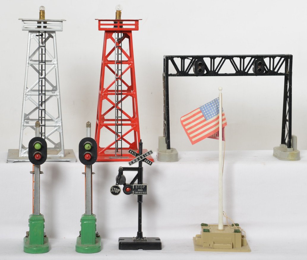 Lionel 494, 153, 450, 189, 140, 153, 494: Postwar Lionel O gauge accessories, two 494 beacons, two 153 block signal, 450 overhead signal bridge, 140 banjo signal, and 189 flagpole. Beacons are missing lamp heads. Accessories look C6.