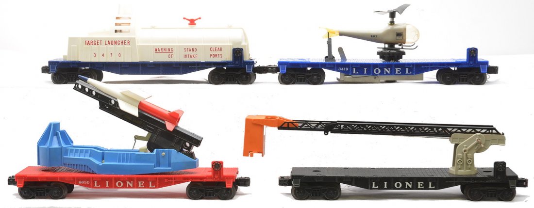 Lionel Freight Cars 3419 3470 6512 6650: Lionel postwar freight cars; 3419 flatcar with a broken Navy helicopter, 3470 target launching car missing the plastic cage blower and balloons, 6512 cherry picker and a 6650 rocket launcher car with 