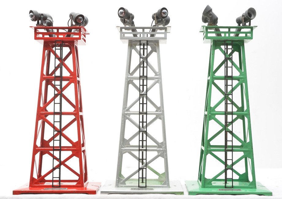 Lionel 395 Aluminum 395 Green 395 Red Towers: Lionel postwar three 395 floodlight towers, one aluminum, one green and one red. The red tower has been partially repainted. The aluminum tower has green paint spray on the bottom part of the structur
