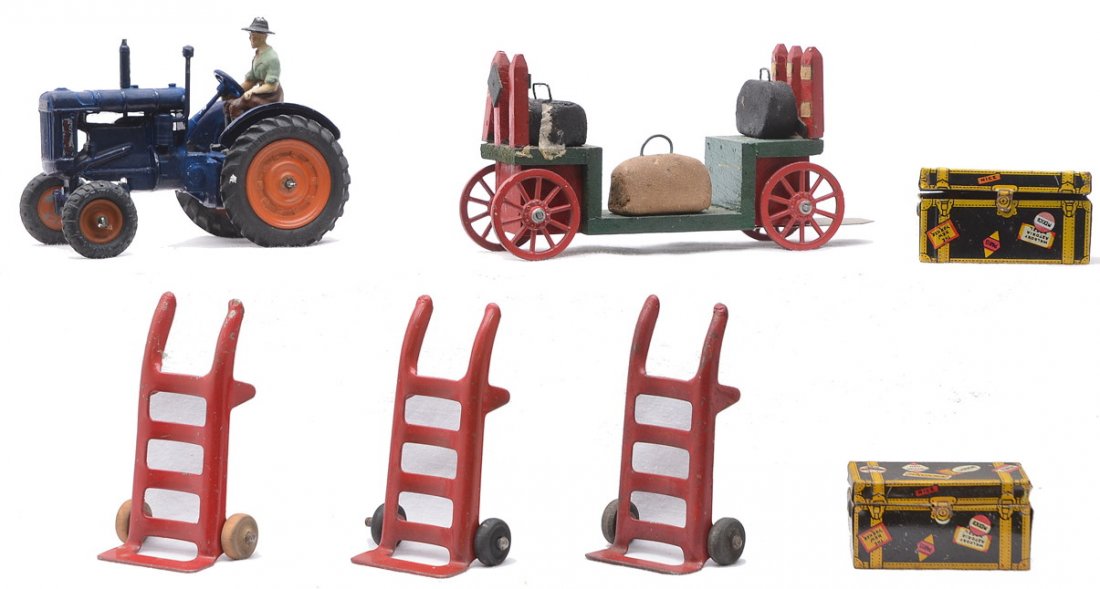 Britains Fordson Tractor Marx Hand Trucks Luggage: Britains blue die cast Fordson Major Farm Tractor with farmer driver, three Marx hand trucks, two Marx lithographed luggage pieces and a baggage cart, manufacturer unknown. Please view photo to verify