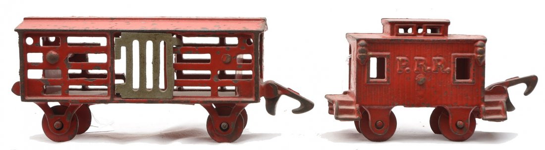 Hubley Floor Toy Red Stock Car & Caboose: Hubley cast iron floor toy freight cars including; red stock car with sliding doors that measures 7 inches in length and a red PRR caboose that is nearly 5 inches in length. The stock car has broken s