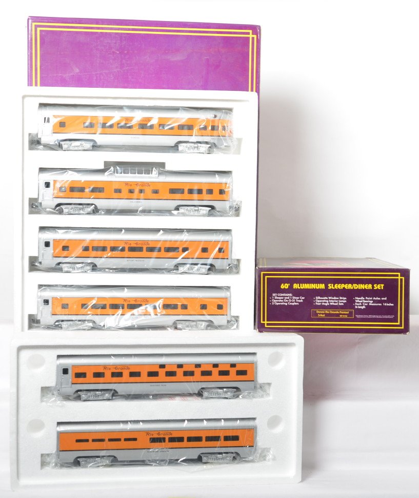 MTH Rio Grande seven car aluminum passenger set: MTH modern O gauge MT-6002 Rio Grande aluminum painted five car passenger set in OB. Also includes MT-6102 sleeper / diner add on. Set is C9 with no major signs of run time. OBs have some light dust a