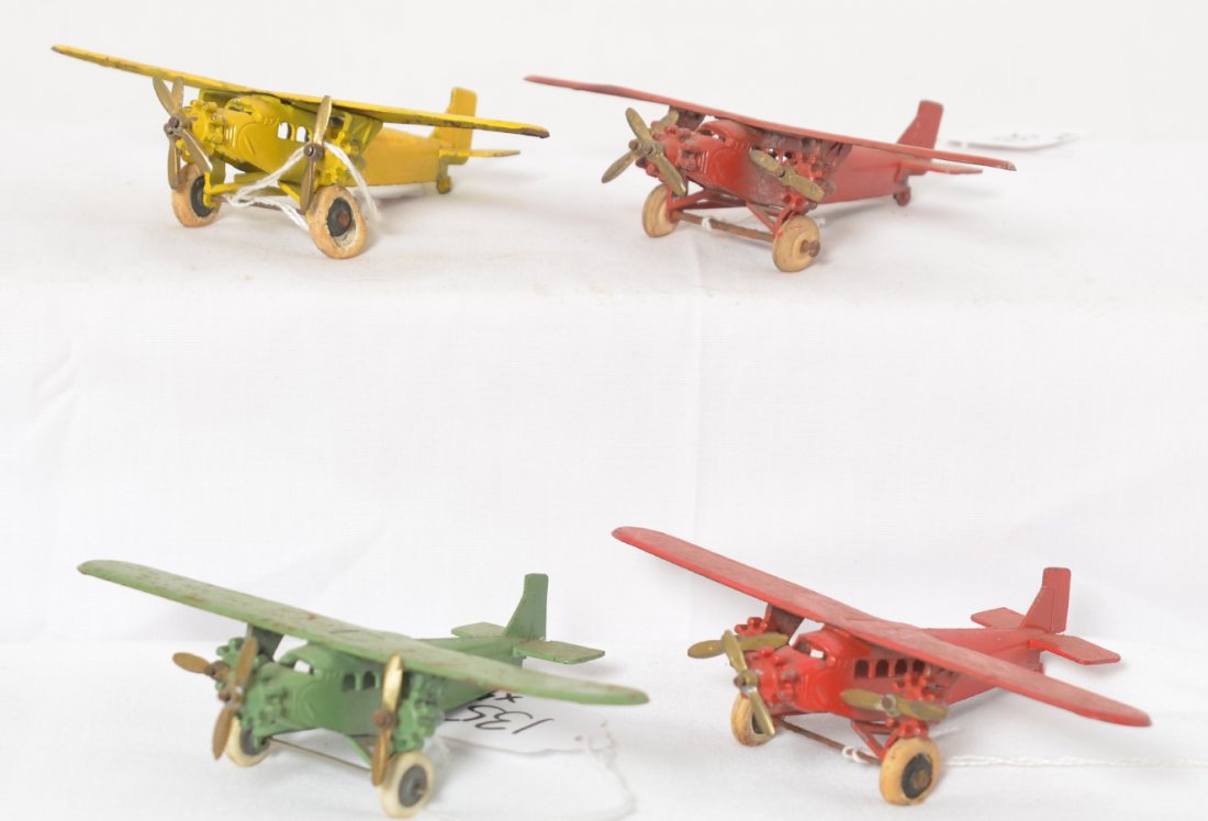 Four Tootsietoy Ford Tri-motor passenger/mail airplanes: Four Tootsietoy Ford Tri-motor passenger/mail airplanes with multiple cylinder rotary engines. Yellow and one red plane appear to have touchups. Rest look original with original tires except green.
