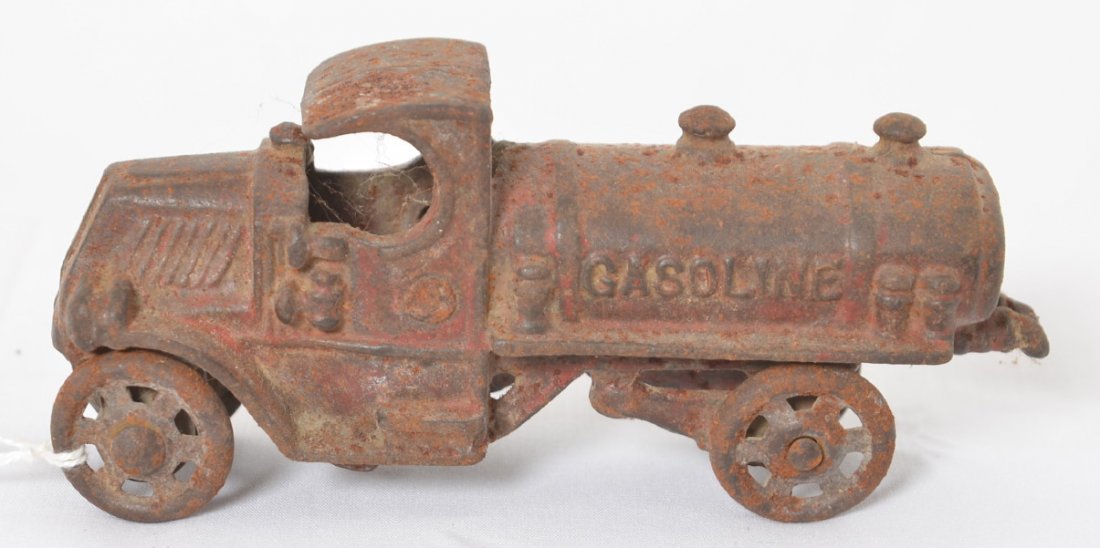 Cast iron Gasoline truck w/rear spouts early Mack: Cast iron Gasoline truck with rear spouts early Mack truck with spoked steel wheels. Truck has rust, some red paint. Truck has casting numbers. Truck measures approximately 5 inches long.