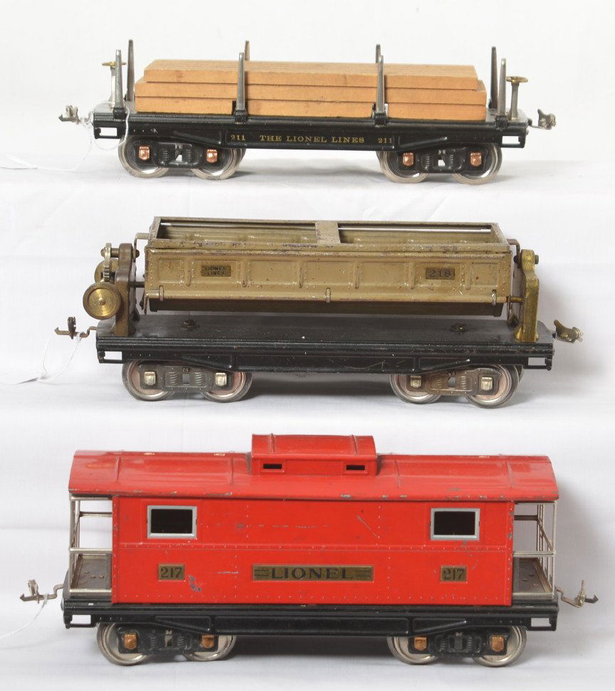 Lionel standard gauge 211, 217, 218 freight cars: Lionel prewar standard gauge trains including restored 211 flat with lumber load, repainted 217 caboose, and 218 dump car. Trains are C6-7.