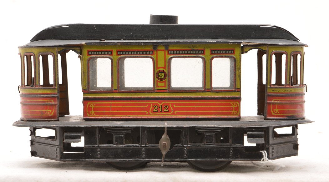 Gunthermann German Tin Clockwork Trolley: Gunthermann prewar German tin lithographed orange and green clockwork trolley. The trolley is marked SG on the sides which stands for Sam Gunthermann and is numbered 212. Roof appears to be repainted.