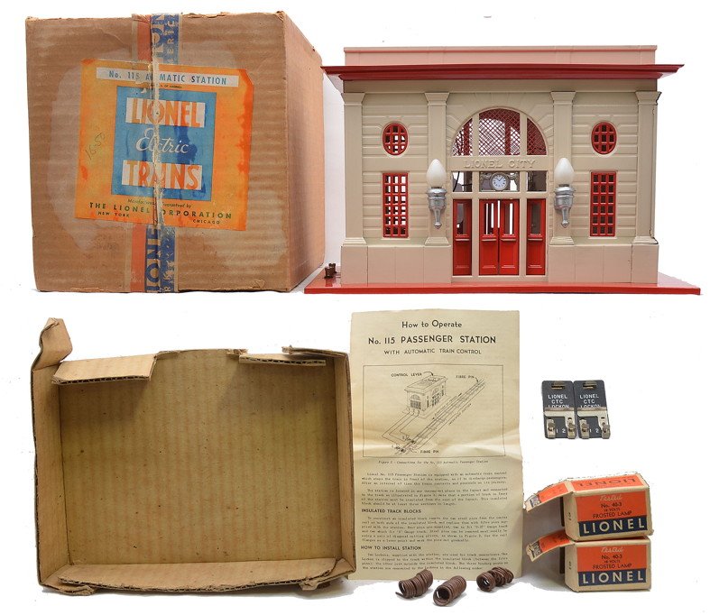 Lionel 115 Automatic Station Ivory/Red Boxed: Lionel postwar 115 automatic Lionel City station with red base, door, window inserts and skylight, ivory walls, nickel clock, aluminum painted light fixtures, two 40-3 frosted 18V lamps in individual 