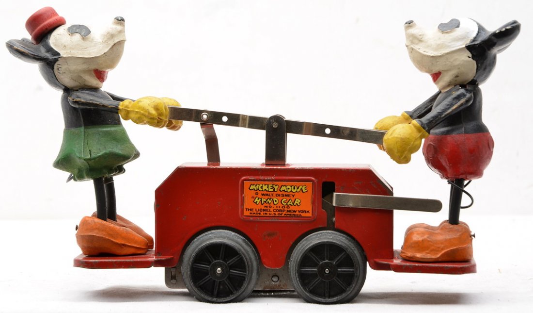 Lionel 1100 Red Mickey and Minnie Hand Car: Lionel prewar O gauge no. 1100 red Mickey and Minnie Mouse wind-up hand car. Mickey has paint touch up above one eye. Both figures are complete. Hand car is C6-7.