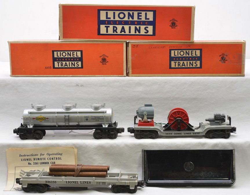 Lionel Freight Cars 64154 3650 3361-55 Boxed: Lionel postwar freight cars including; 6415 silver Sunoco three dome tank, 3650 searchlight extension car and a 3361-55 operating lumber car with lumber load, 160 bin and instruction sheet in OBs. The