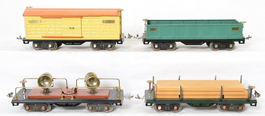 Lionel 511, 512, 514, and 520 S.G. freight trains: Prewar Lionel standard gauge 511 flatcar with lumber load, 512 gondola, 514 boxcar, and 520 operating searchlight car. Trains have been restored to look C7 area, except 512 is original and missing a c