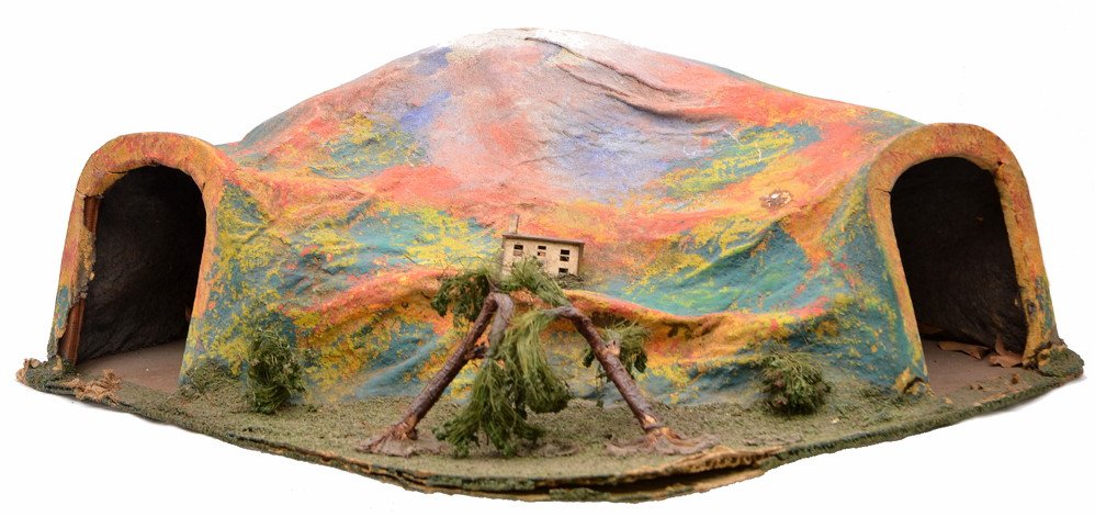 Lionel 123 90-Degree Tunnel w/Trees & House: Lionel prewar O gauge 123 90-degree tunnel with composition corrugated paperboard base, hand painted with trees, shrubs and metal house. The base is beginning to separate in areas. The trees are bent.