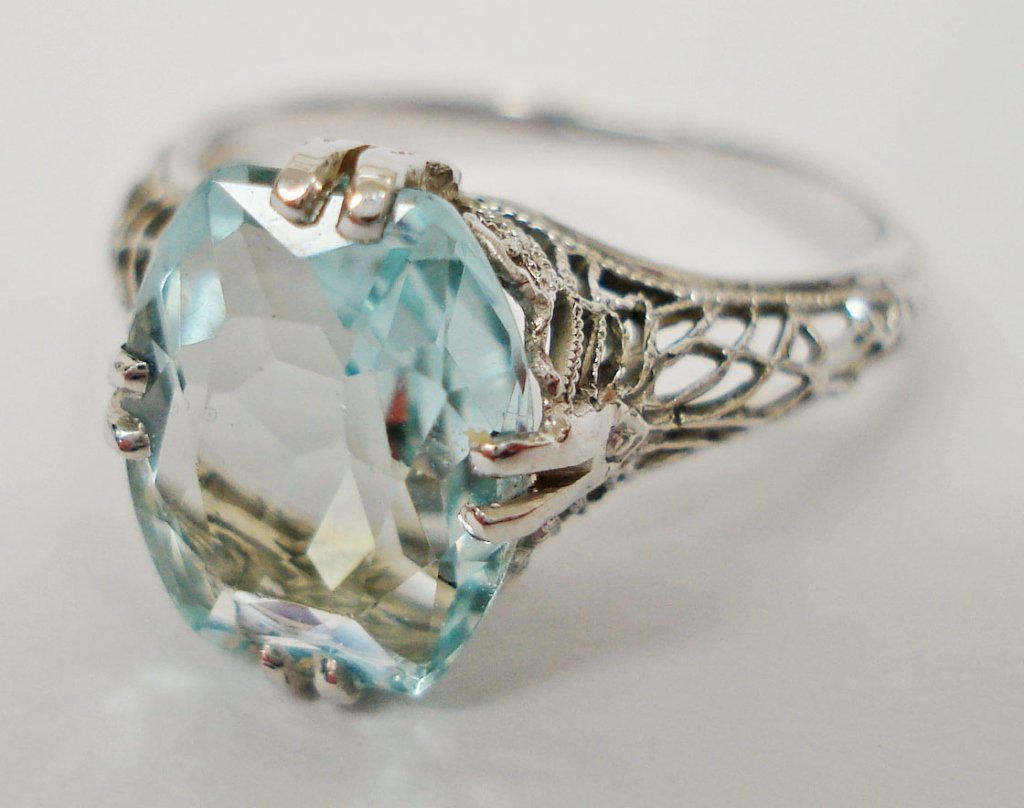 18K White Gold Aquamarine Ring: Lady's Solitaire Ring with one cushion faceted blue aquamarine measuring approx. 10x8mm, 18K white gold filigree style ring, 1.53 dwt, ring size 5-1/2