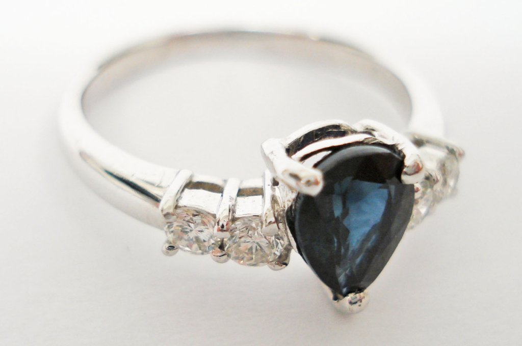 Platinum Diamond and Sapphire ring: Lady's Ring With center pear faceted Sapphire weighing approx. 1 ct., 4 full cut side diamonds total approx. 0.25 cts., VS clarity, near colorless, platinum, 2.46 dwt, ring size 5-1/2