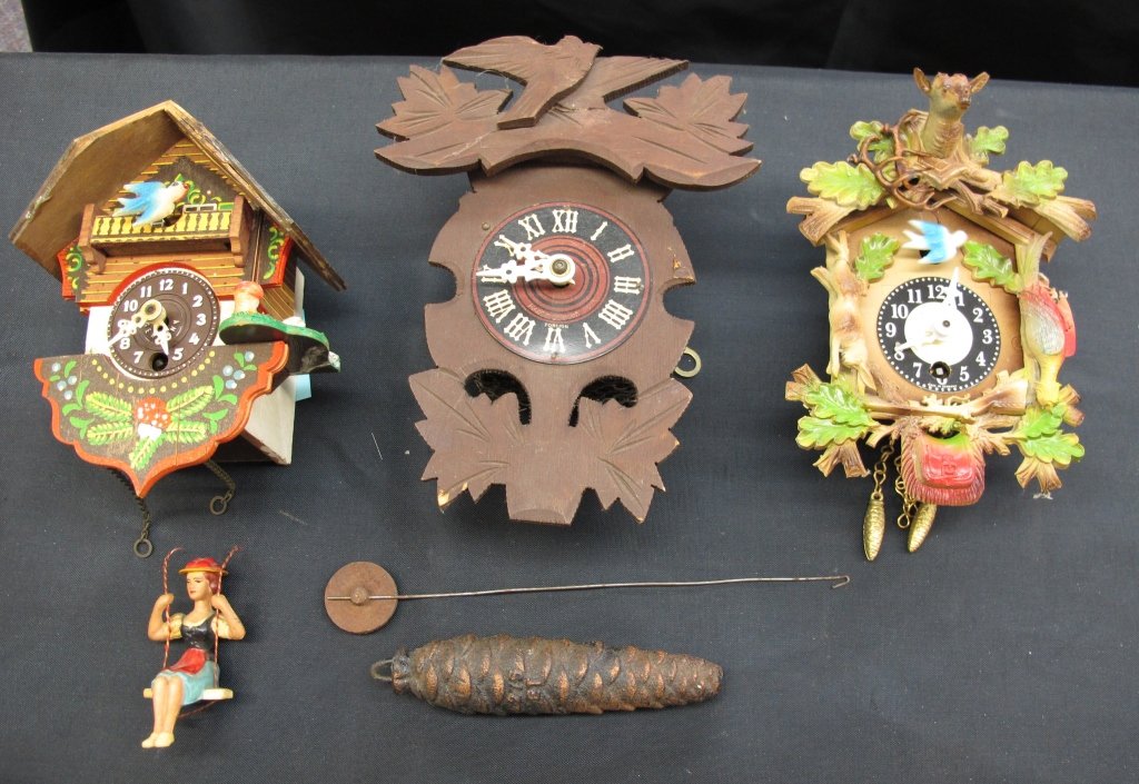 3 German Wall Clocks: 3 German Wall Clocks, all are running but need cosmetic repair: Small Clock, chalet motif, lady on swing bounces on swing, needs to be re-strung, H. 5-1/2"; Wooden Wall Clock, with one weight and pend