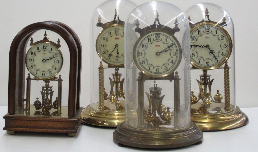 4 Anniversary Clocks: 4 Anniversary Clocks, all appear to have no missing or broken parts: Kundo, wooden and glass casing H. 10"; Kundo, glass globe, H. 11-1/2"; Kundo, glass globe, H. 11-1/2"; Heco, plastic globe, H. 11-1