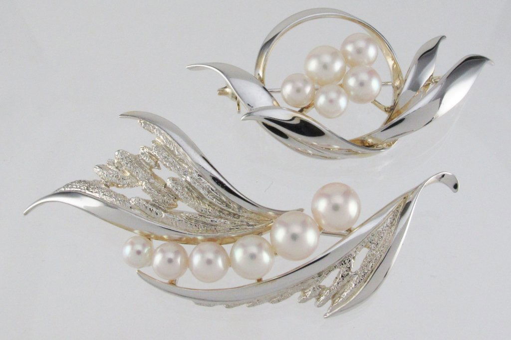 2 Mikimoto Sterling and Pearl Brooches Ca. 1960: 2 Signed Mikimoto Sterling and Pearl Brooches, authentic hallmark, one is 2-1/2" in width, 6.63g, 6 pearls range 4 to 6 mm each; the other is 2" in width, 6.43g, 5 pearls range 5 to 6 mm each, both ci