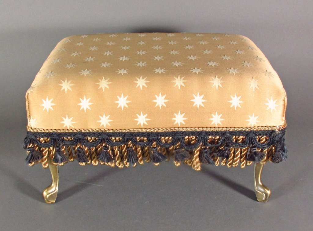 Upholstered Footstool: Upholstered Footstool, gold upholstery with gold and black tassels, metal feet, H. 9-1/2", L. 16", W. 13"