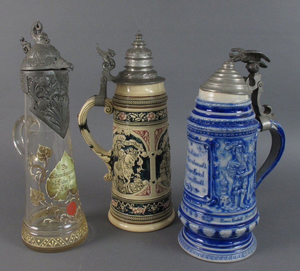 3 German Steins: 3 German Steins: Pewter lid, ceramic decorated in cream, dark green and rose, some chips along mouth of stein, H. 15-1/4" ; Blue and grey ceramic stein, Hanz Rudolf Manuel 1547, Hermann Manuel 1547 un