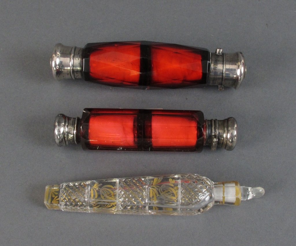 3 Perfume Vials: 3 Perfume Vials: 2 Double Ended, faceted glass, ruby tinted, screw-on lid and flip, covers are sterling silver with 14 K gold centers, L. 4-1/4" ; Ruby tinted glass, flip-top lid with glass stopper on
