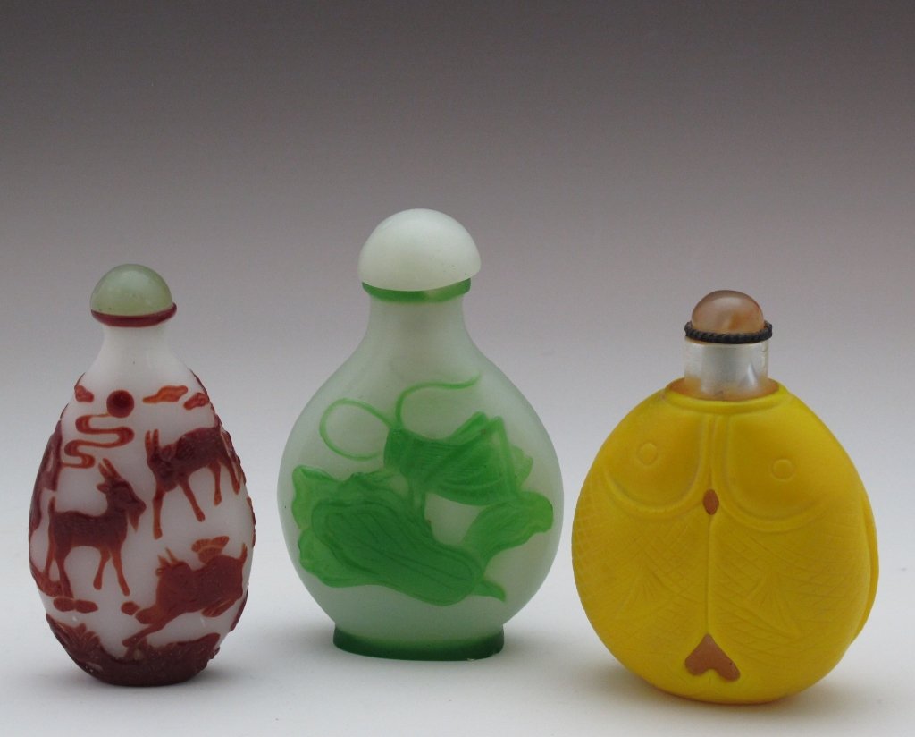 3 Asian Glass Overlay Snuff Bottles: 3 Asian Glass Overlay Snuff Bottles, one is carved red glass goat design over white glass, one is carved green glass grasshopper design over white glass, one is yellow fish design, average height 3"