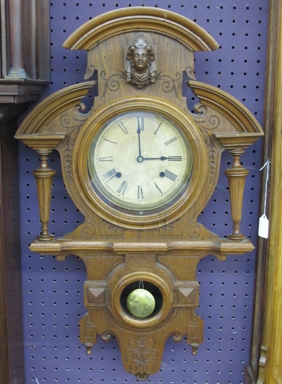 19th C Ansonia Victorian Wall Clock: Ansonia Victorian Wall Clock, 19th century, wood case, figurehead carved at crest, original movement has been replaced with battery operated movement, original movement is included (boxed), clock