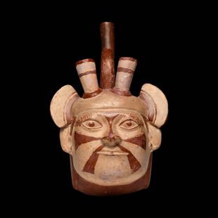 Moche Portrait Head of Dignitary Vessel: Pottery head vessel having a stirrup type spout, depicting a dignitary wearing a horned headdress with side wing-like appendages. The mans face is painted with a star-like pattern. Similar horns can b