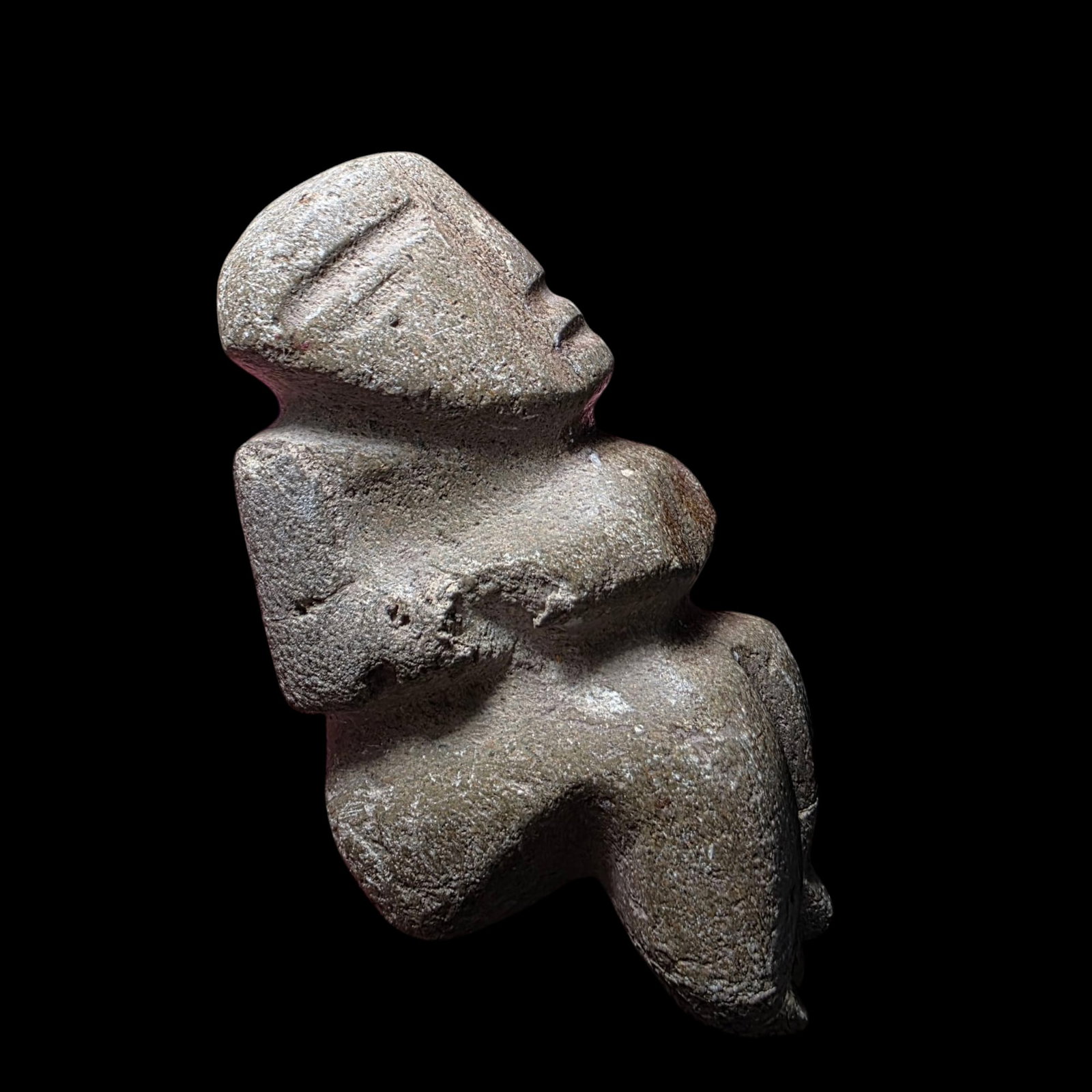 Pre-Columbian Chontal stone seated figure: Pre-Columbian Chontal stone seated figure is a carved stone artifact attributed to the Chontal culture of ancient Mesoamerica, likely dating from 600–900 CE. The figure is stylized, with a geometric