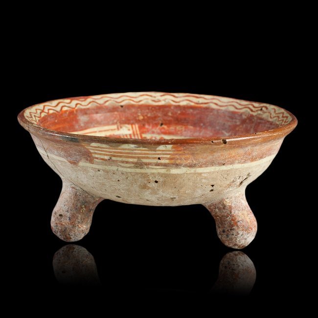 Pre-Columbian Michoacan Rattling Tripod Grater Bowl: A polychrome tripod grater bowl from ancient Michoacan West Mexico, circa 1000 A.D. – 1500 A.D. Features painted decoration in two shades of red and white pigment. The bowl sits atop three bulbous t