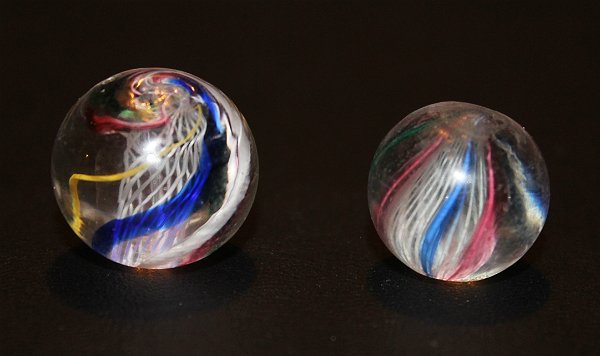 Antique Handmade German Swirl Marbles Latticino Core: Lot of 2 antique handmade German swirl marbles with white latticino cores. The smaller of the two marbles features pink, green and blue and the larger features similar alternating colors just below th