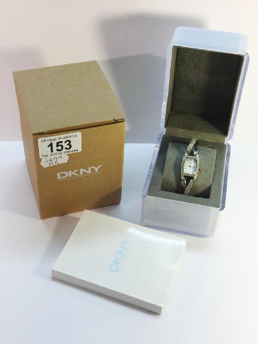 A DKNY Ladies Wrist Watch in Stainless Steel set with: A DKNY Ladies Wrist Watch in Stainless Steel set with crystals. Mother of perl colour face. In original box.