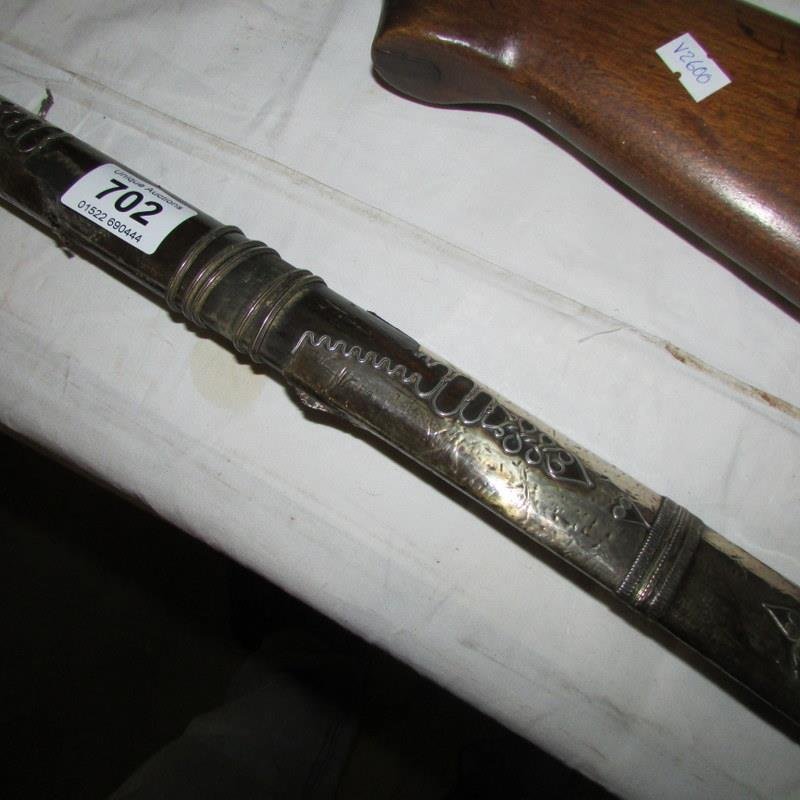 An Arabian sword with silver decorated scabbard (some