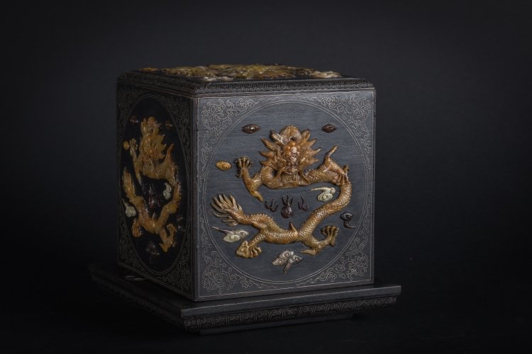 A seal container: China, Qing Dynasty, 19th Century An impressive quadrangular dark wood box with metal thread insertions and soapstone encrustation depicting dragons set amidst clouds and flames. The interior is engra