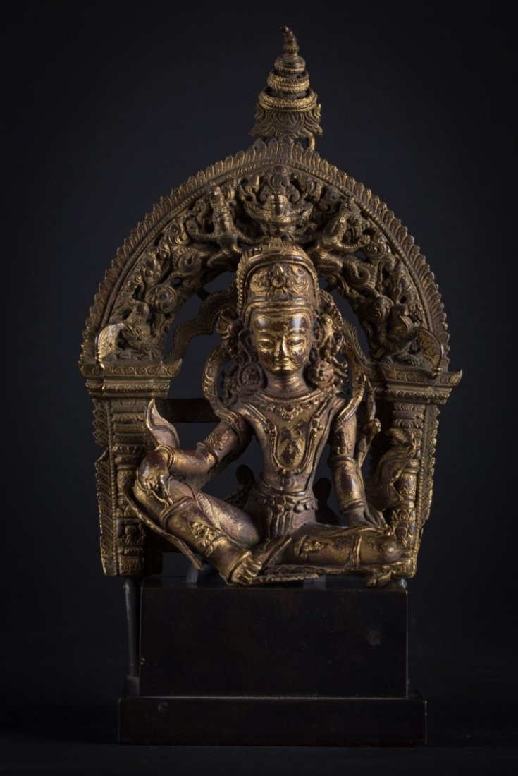 A figure of Indra: Nepal, circa 17th-18th Century An important copper alloy cast with reddish tones depicting the Hindu god Indra. There are evident traces of gilding alternating with strong patina. With a serene almost
