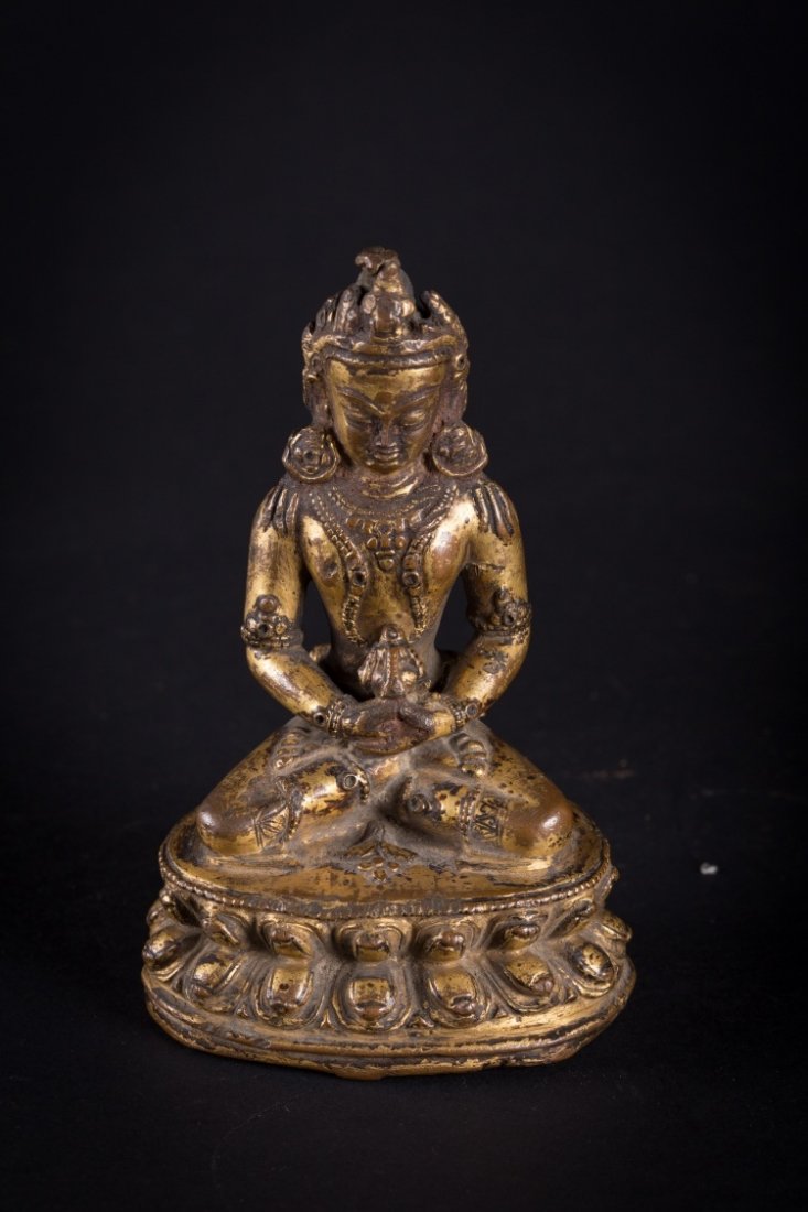 A figure of Amitayus: Tibet/Nepal, 15th-16th Century A copper alloy cast of the Transcendent Buddha Amitāyus (Tshe-dpag-med Iha-dgu). With a strong patina and wear from age, traces of gilding are still visible. Seated
