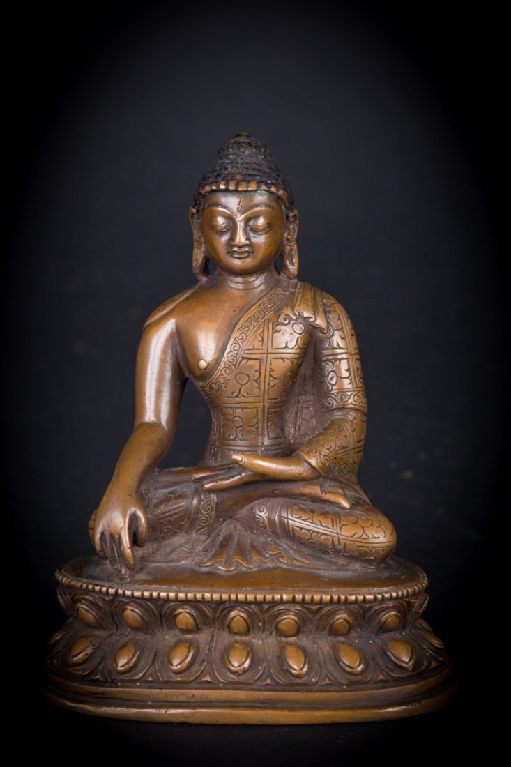A statue of Sakyamuni: Tibet/Nepal, 19th-20th Century An elegant copper alloy cast of the Historical Buddha Śākyamuni (Śākya-thub-pa), represented here in his classical posture with the left hand touchin