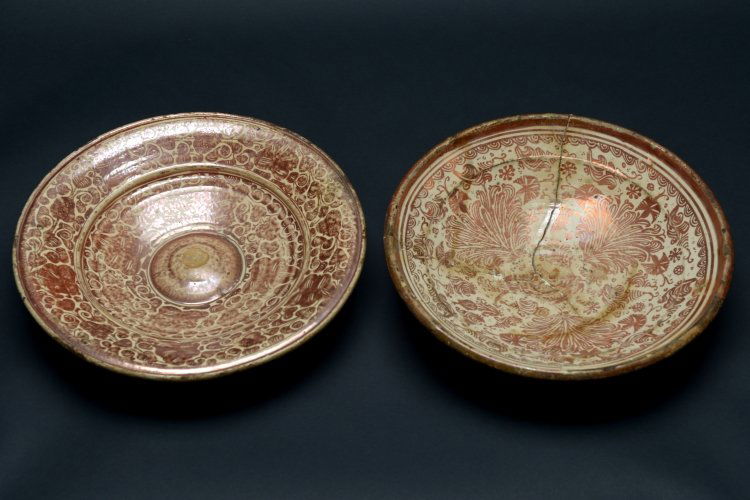 A pair of Valencian lustreware: Spain, Valencia (Manises), 17th - 18th CenturyEnamelled earthenware decorated with brown lustre A lot composed of an umbonate vessel (diam. 38 X h. 7cm) with plant motifs on the interior and metal rin