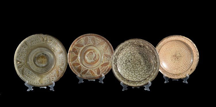 Four Hispano-Moresque plates: Spain, Valencia (Manises), 17th - 18th CenturyEnamelled earthenware with lustre decoration A series of Hispano-Moresque plates painted with brown lustre.The two umbonate bowls with slightly pod motifs