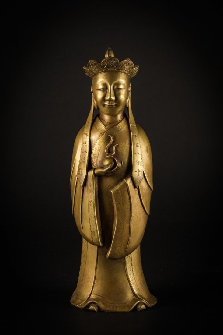 A bronze figure: China, early 19th Century A bronze-gilt cast soberly chased figure, depicting a standing and elegantly dressed Buddhist monk. h 37 cm
