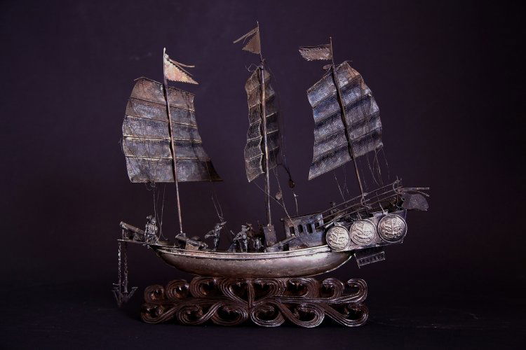 A silver model of a Chinese junk: China, Qing Dynasty, mid-19th Century A rare silver model of a war sailing vessel. An unusual and detailed object, depicting the classical Chinese junk fitted with cannons and spread sails with stenda