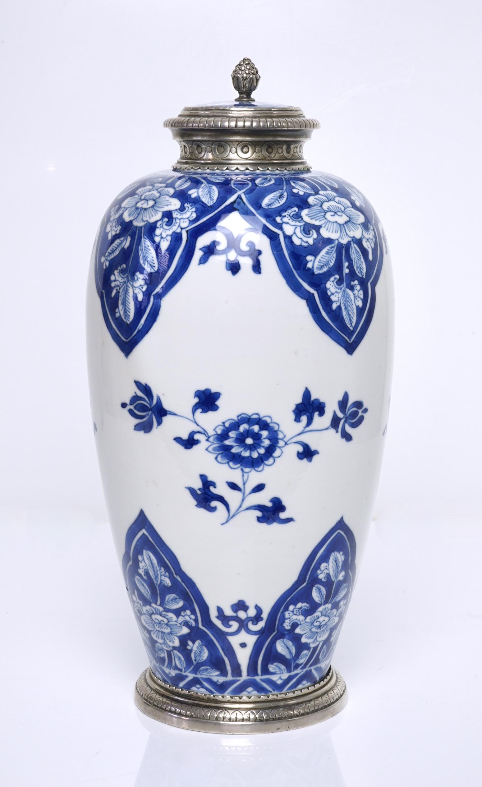 A Chinese blue and white bottle, Kangxi period.: The blue and white bottle decorated with flowers within reserves with later silver mounts, 27cm height. Provenance: Private collection of Mr. Steven Tyler.