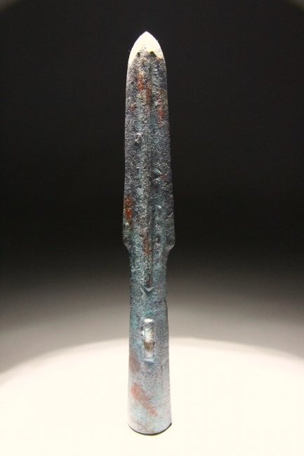 Chinese Warring States Period Spearhead: Ancient China, 475-403 BC. Bronze cast slender spearhead with tubular socket and narrow parallel-sided blade with pierced loop. Lenght: 22cm or 8.5". Weight: 260 grams. Ex UK private collection formed
