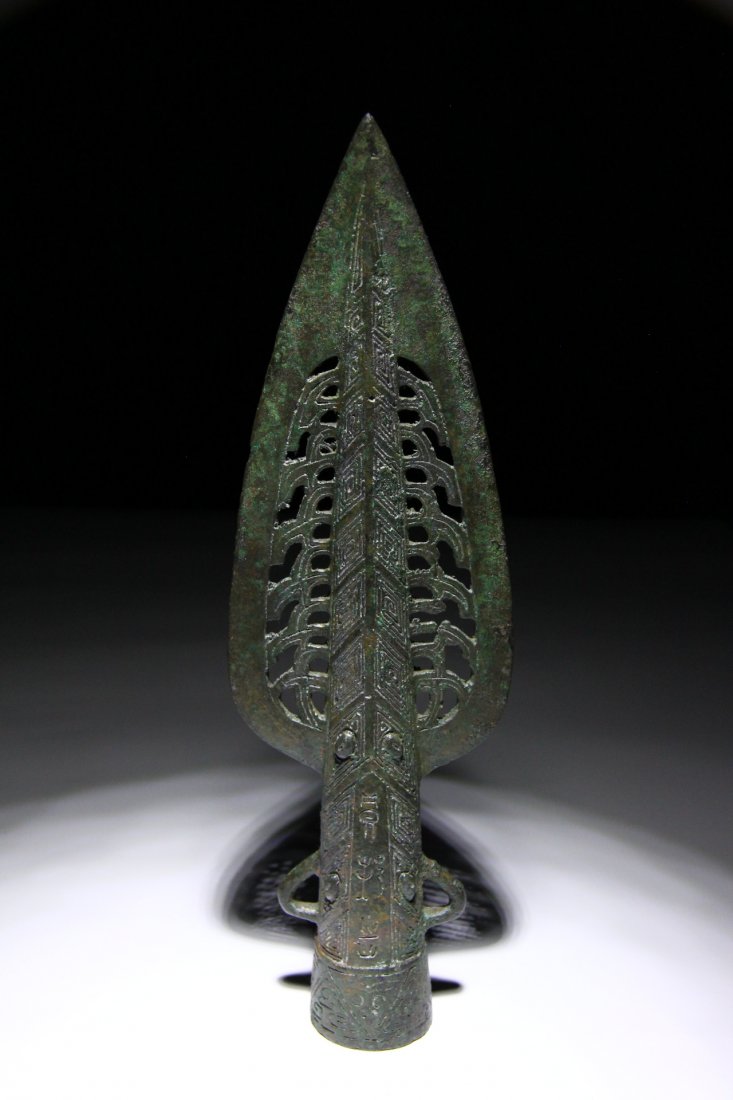 Chinese Shang Dynasty Spearhead: Ancient China, 1600-1046 BC. Bronze cast leaf-shaped spearhead with openwork panels flanking the central midrib, flared socket with collar to the mouth, two lateral loops. Length: 24cm or 9.5". Weight